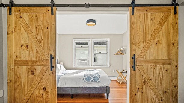 A bedroom with a bed, a window, and a ceiling light.