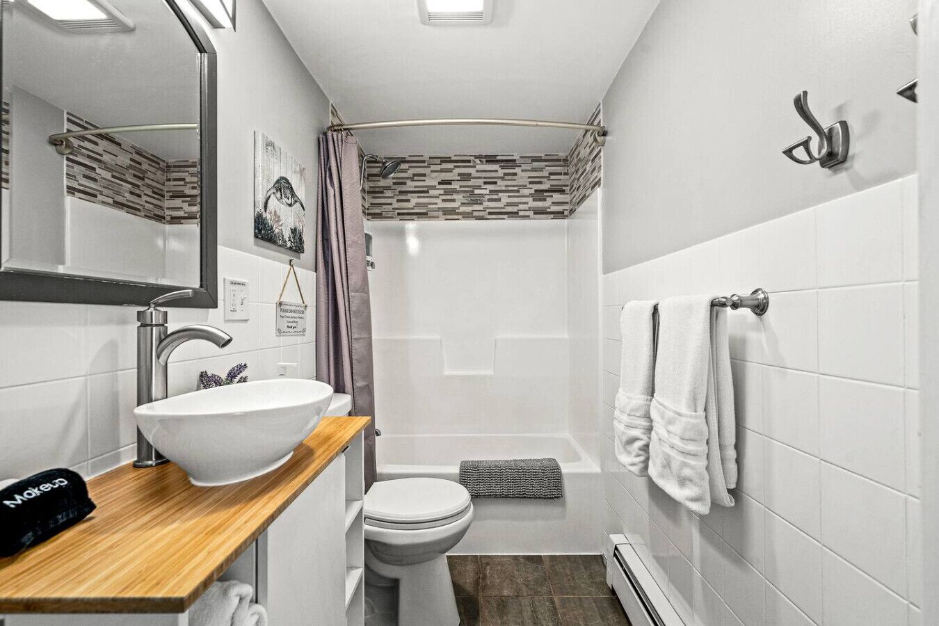 A modern bathroom with a white sink, mirror, and shower.