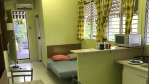 Une cuisine compacte comprenant un lit, une table à manger et un petit réfrigérateur.