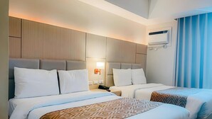 A hotel room with two beds, a ceiling fan, an air conditioning unit, and a window with curtains. - Sotogrande Neopolitan Hotel (Quezon City)