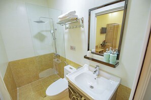 A bathroom with a toilet, sink, shower, and a mirror. - Khanh Uyen Hotel (Xuan Huong - Da Lat)