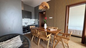 Un comedor moderno con una mesa y sillas de madera, una silla trenzada y una lámpara colgante.