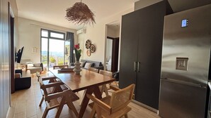 Una cocina moderna con un refrigerador grande, una mesa de comedor de madera y sillas.