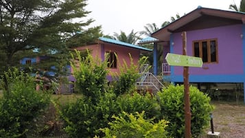 A two-story building with a purple exterior and a blue roof. There is a signpost in the foreground with directional arrows.