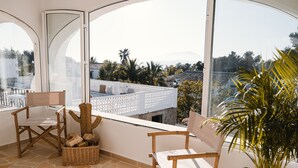 A balcony with wicker chairs, a cactus, and a potted plant. - Villa Boho Ibiza Style (Jávea)