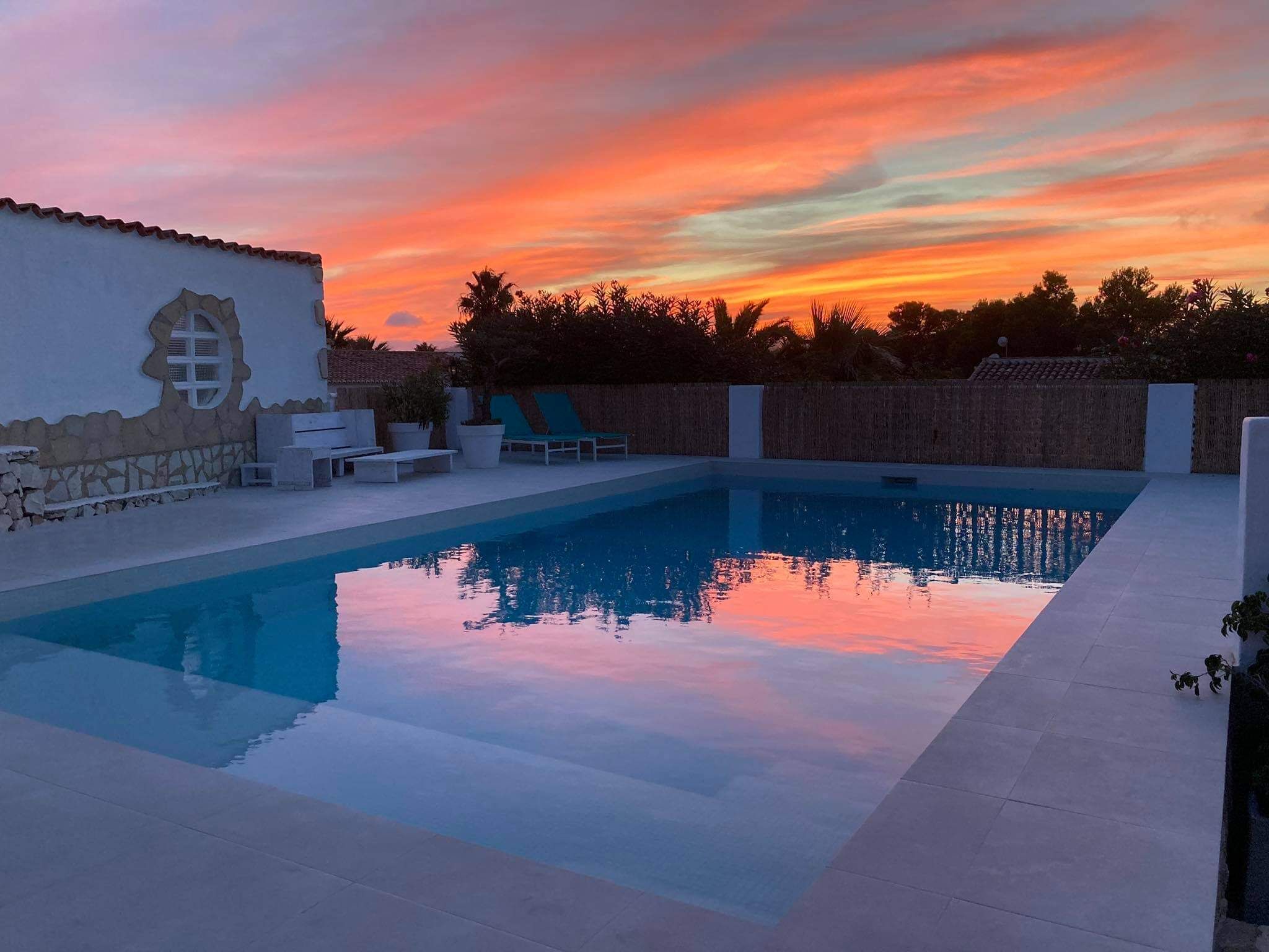 A swimming pool with lounge chairs and a decorative wall.