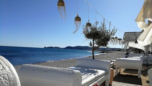 A beachside lounge area with white lounge chairs and a wooden deck. - Villa Boho Ibiza Style (Jávea)