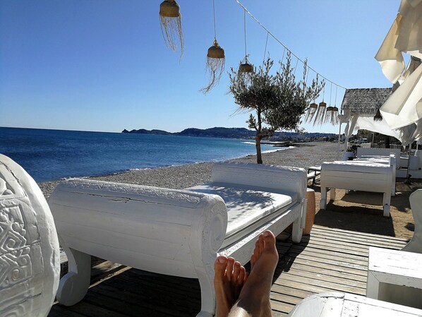 A beachside lounge area with white lounge chairs and a wooden deck. - Villa Boho Ibiza Style (Jávea)