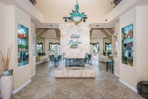 A spacious lobby with a central fireplace, multiple seating areas, and framed artwork on the walls. - Club Bahia Island Sunsets (St Petersburg)