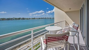 Un balcone con vista su uno specchio d'acqua, un ponte e una costa lontana.