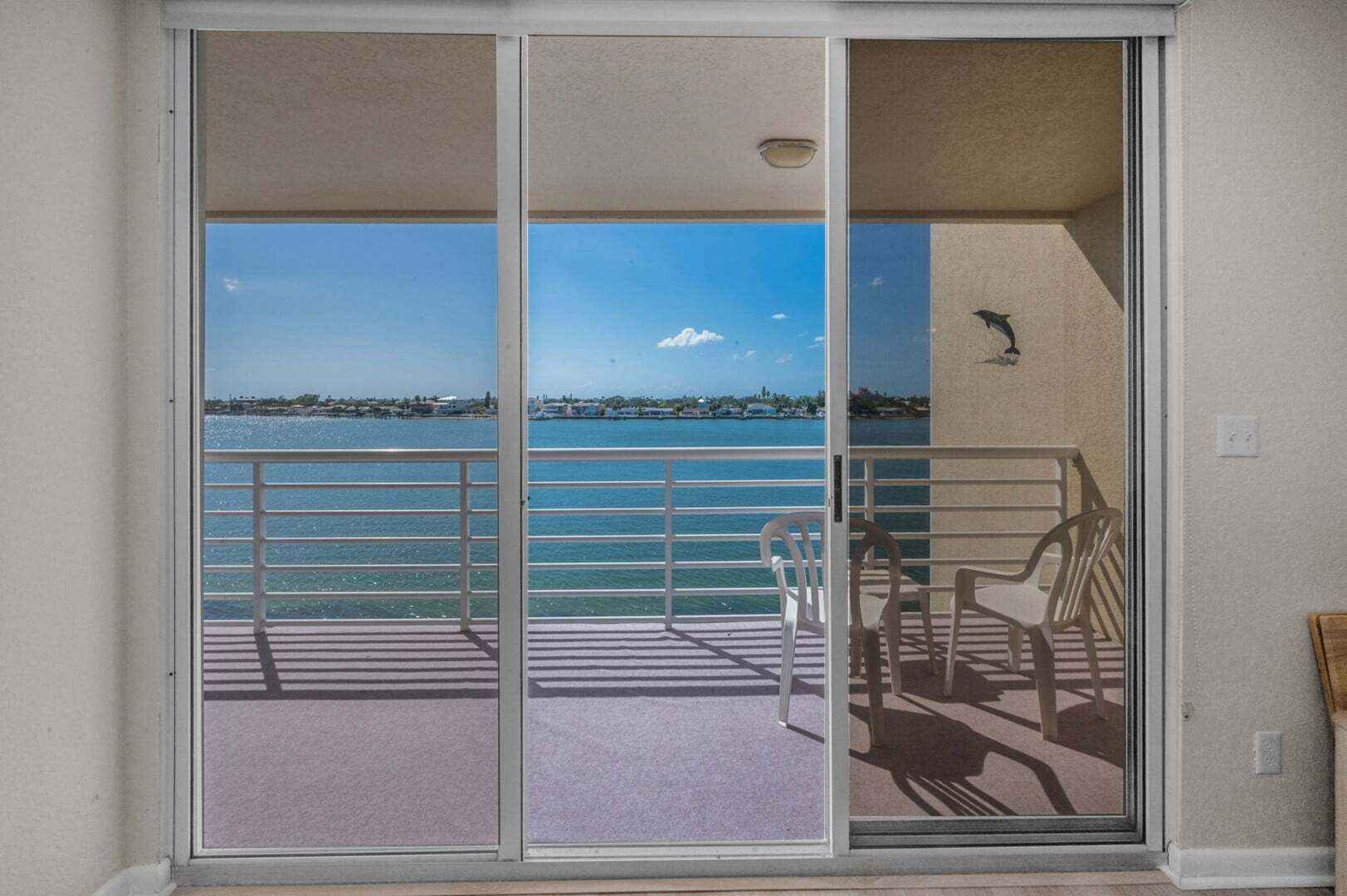 A balcony with a view of a body of water and distant land.