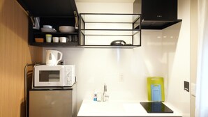 A compact kitchen with a microwave, kettle, and a small sink. - Koti Sopo Universal Bay 1 by Liaison (Osaka)