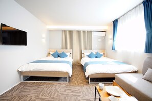 Habitación de hotel con dos camas, un sofá, un televisor y una ventana con cortinas.
