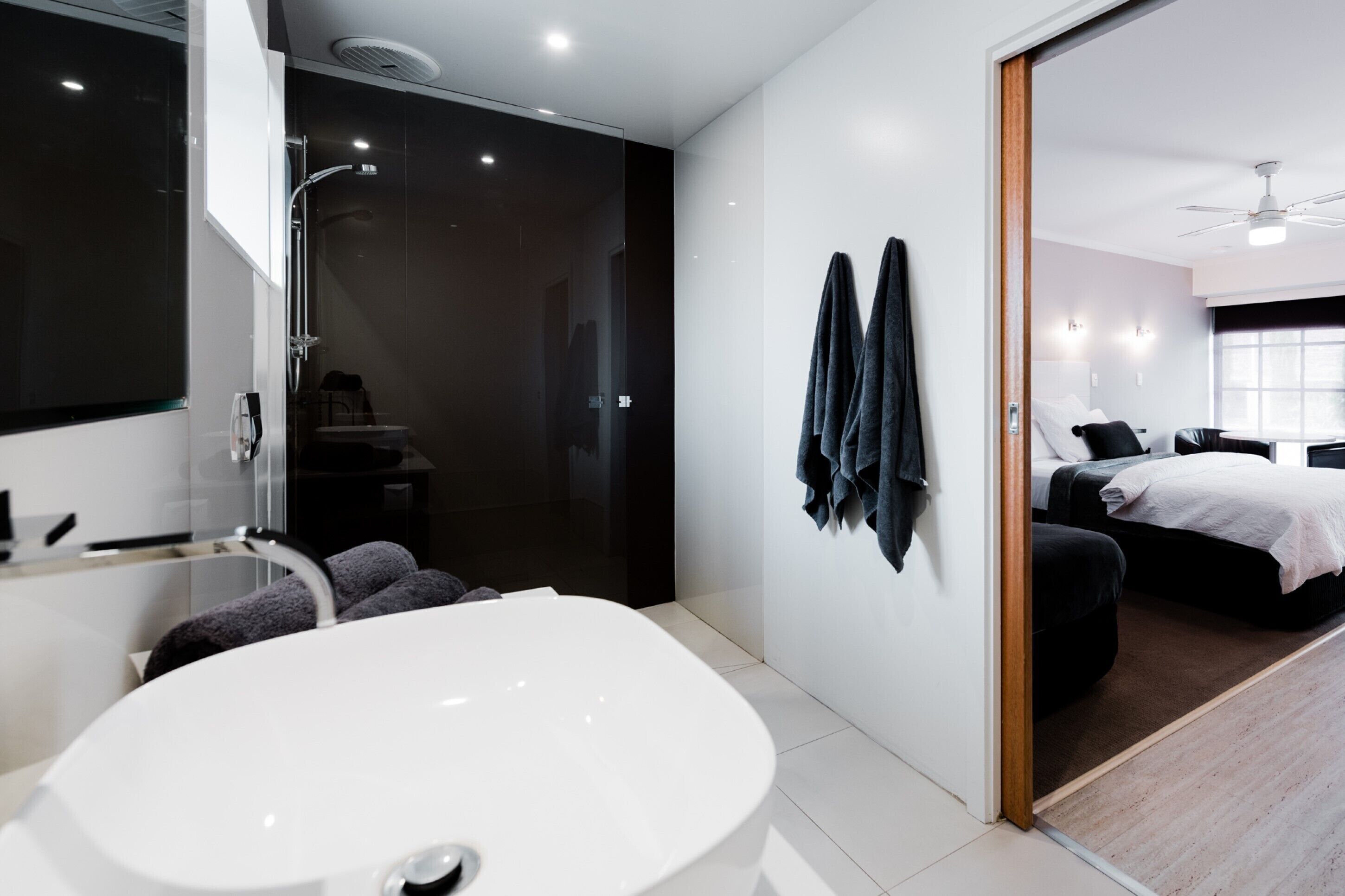 A modern bathroom with a freestanding bathtub, a glass-enclosed shower, and a large mirror.