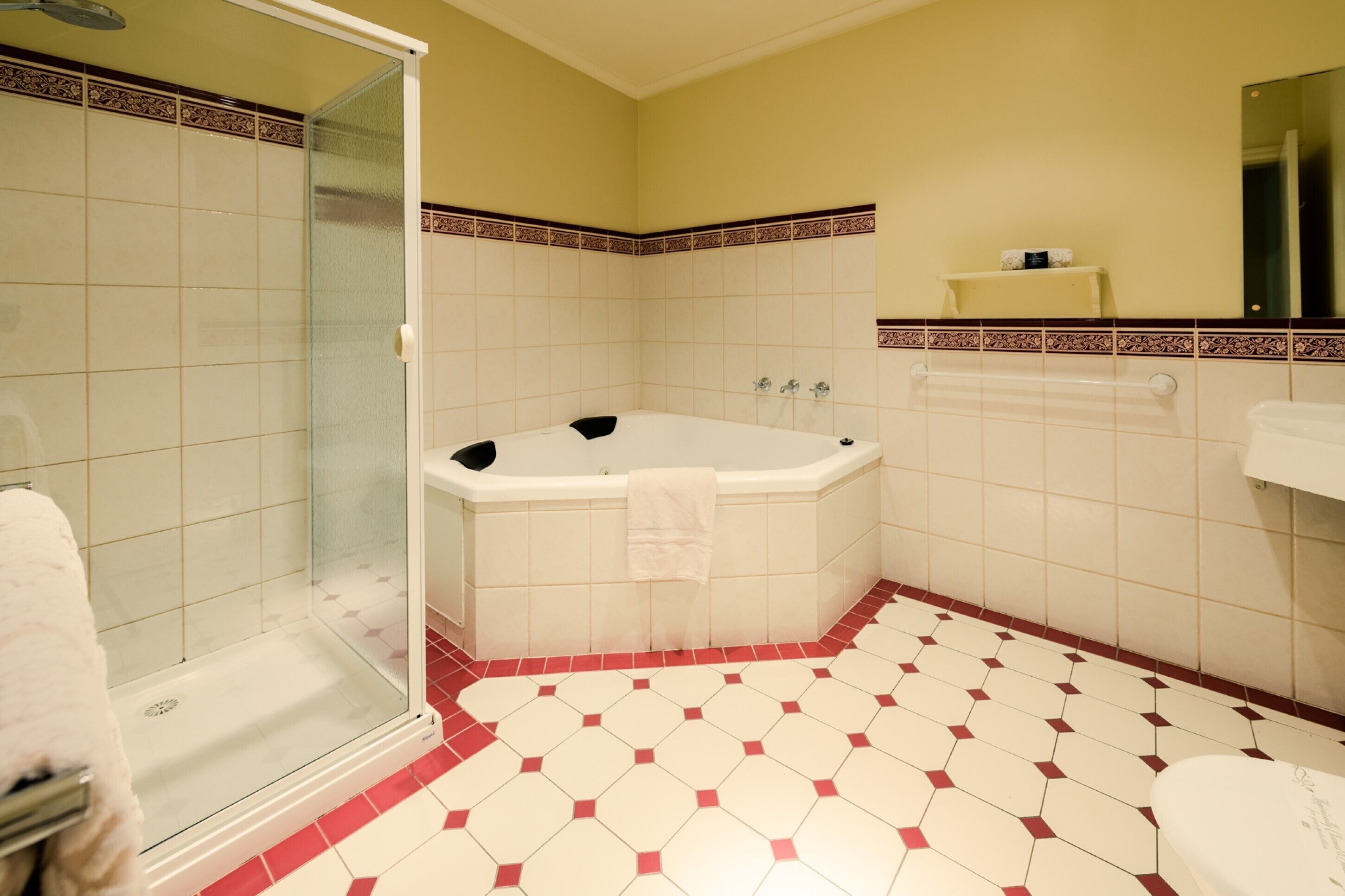 A bathroom with a glass-enclosed shower, a freestanding bathtub, and a toilet.