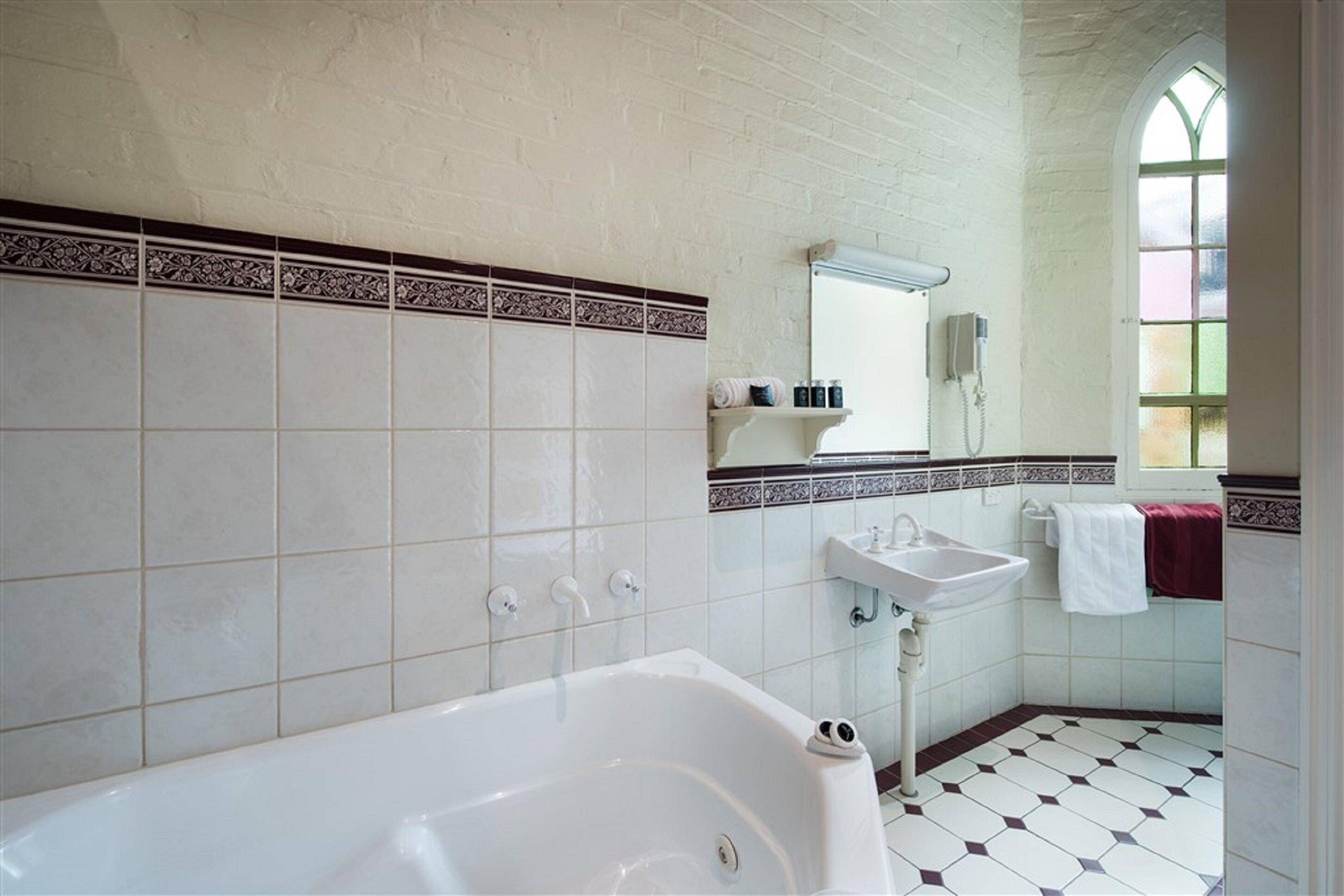 Une salle de bain avec une baignoire blanche, un lavabo et un miroir.