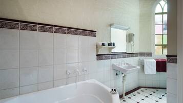 Une salle de bain avec une baignoire blanche, un lavabo et un miroir.