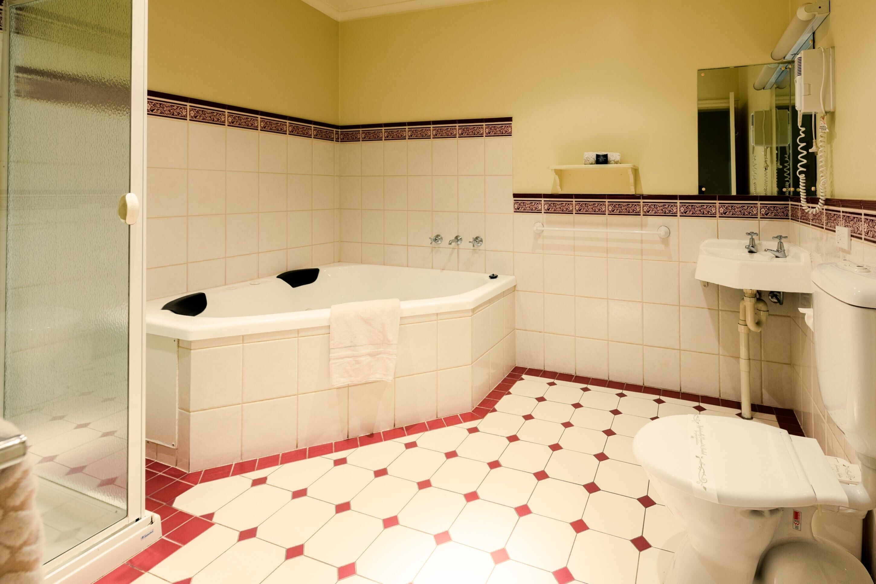 Un baño con bañera, inodoro y lavamanos.
