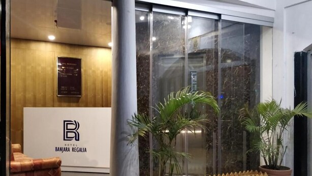 Un área de recepción con una pared de madera, un mostrador de recepción y un amplio ventanal con vistas al interior.