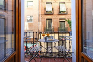 A balcony with a table set for two, featuring a pitcher, cups, and a plate of food. - Tirso Design I (Madrid)