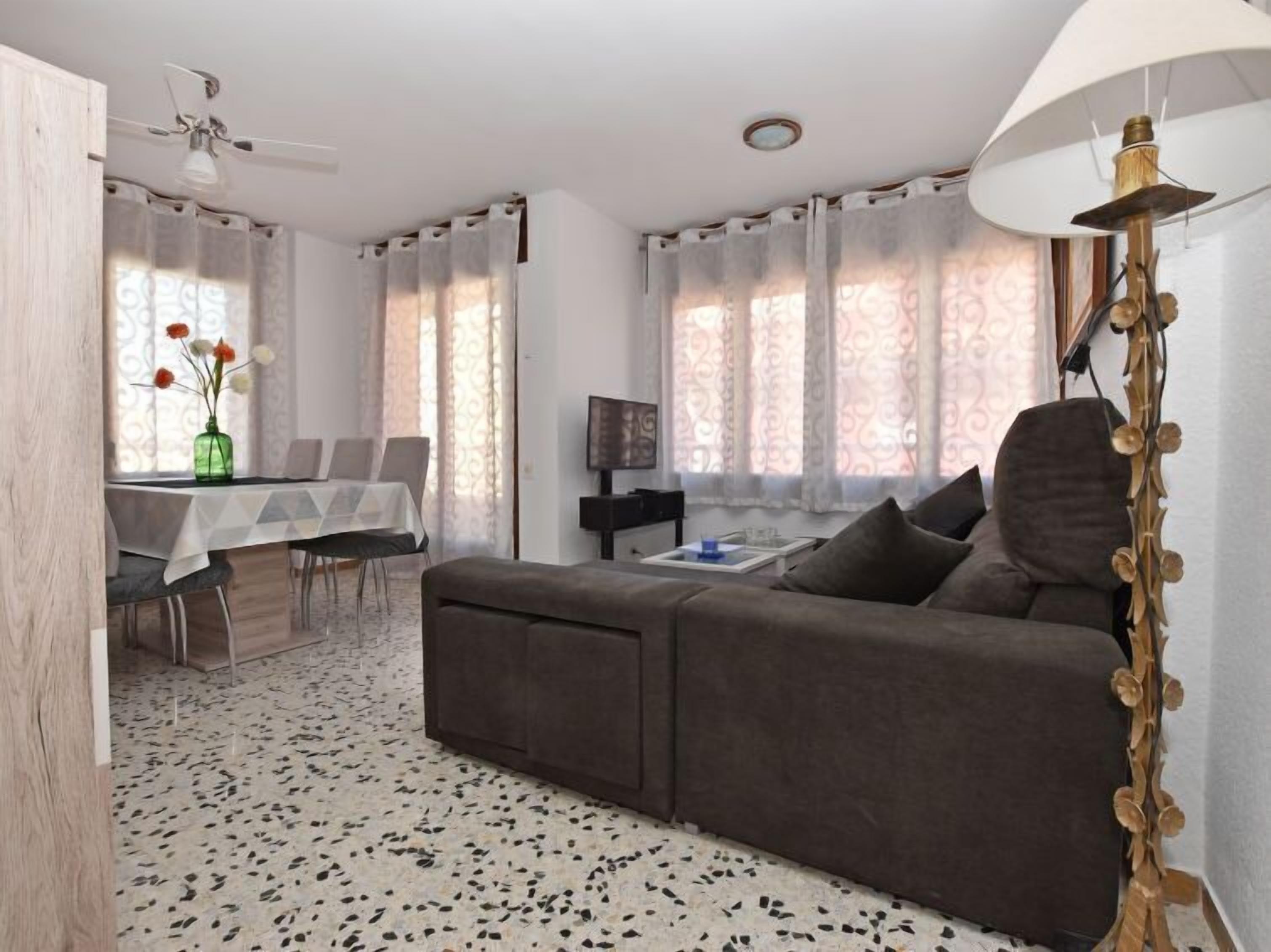 Un salon moderne avec un canapé, une table à manger et un téléviseur.