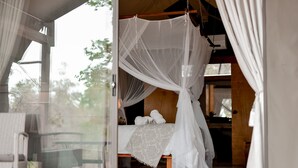 Un dormitorio con cama con dosel, cabecero de madera y vistas al exterior.