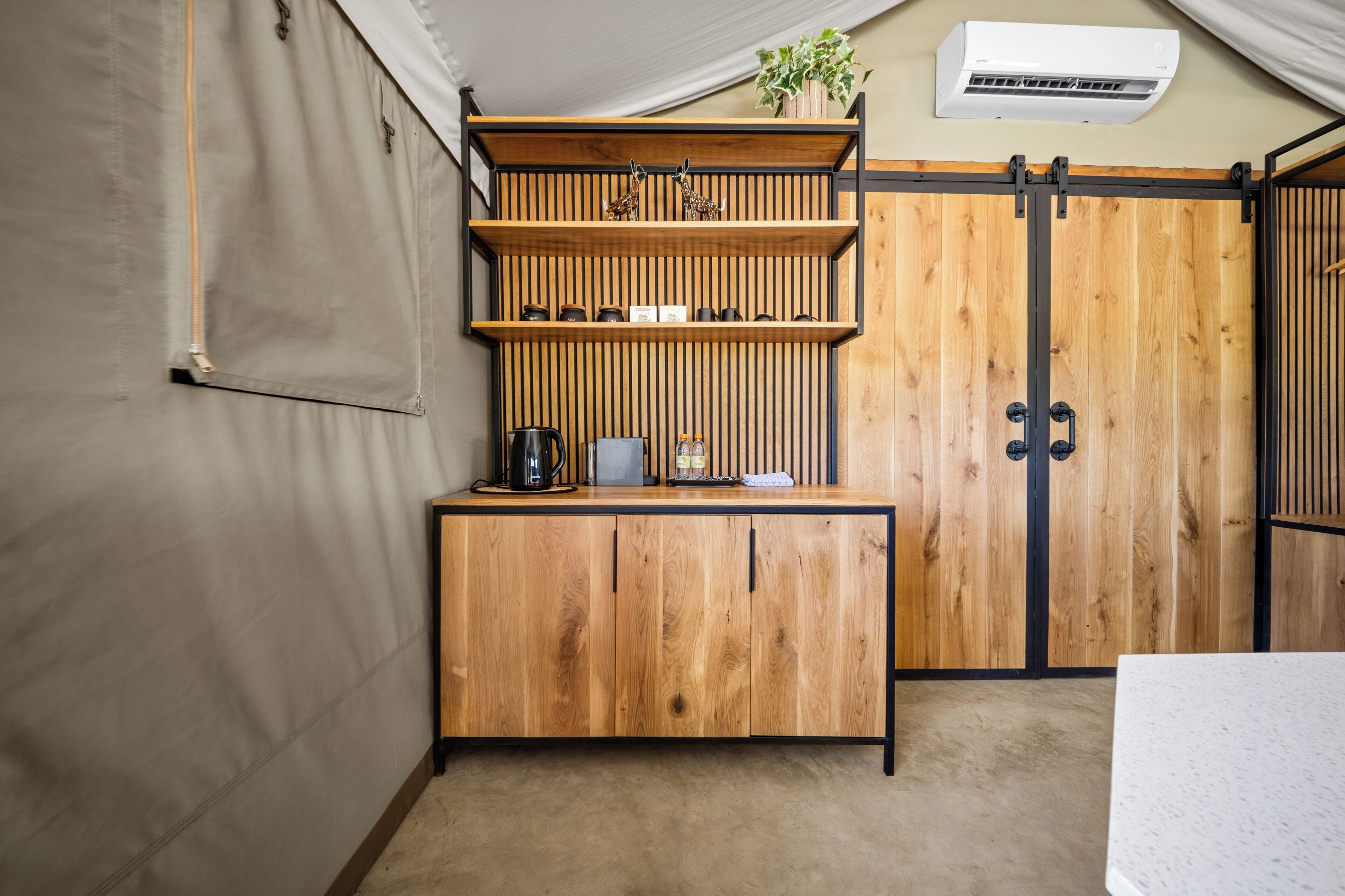 Un mueble de madera con estantes, una cafetera y una planta.