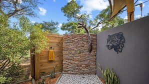 Un muro de piedra con una cerca de madera, una toalla amarilla y un mural de un tigre.