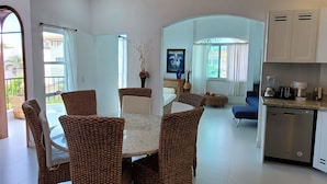 A modern kitchen with a built-in dishwasher, a dining area with wicker chairs, and a ceiling with a circular brick design. - Spacious modern apartment Golden Zone 2F (Bucerias)