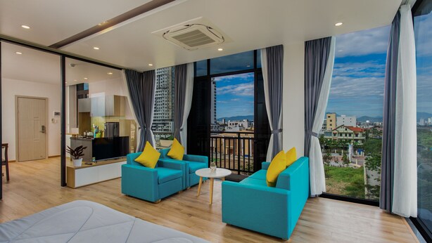 Camera d'albergo moderna con balcone, ampie finestre e vista sulla città.