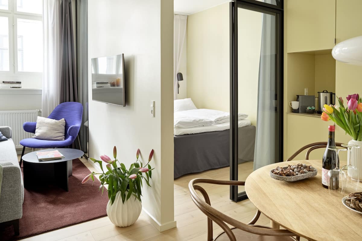 Une chambre d’hôtel moderne équipée d’un canapé, d’une télévision, d’une table à manger et d’un lit.