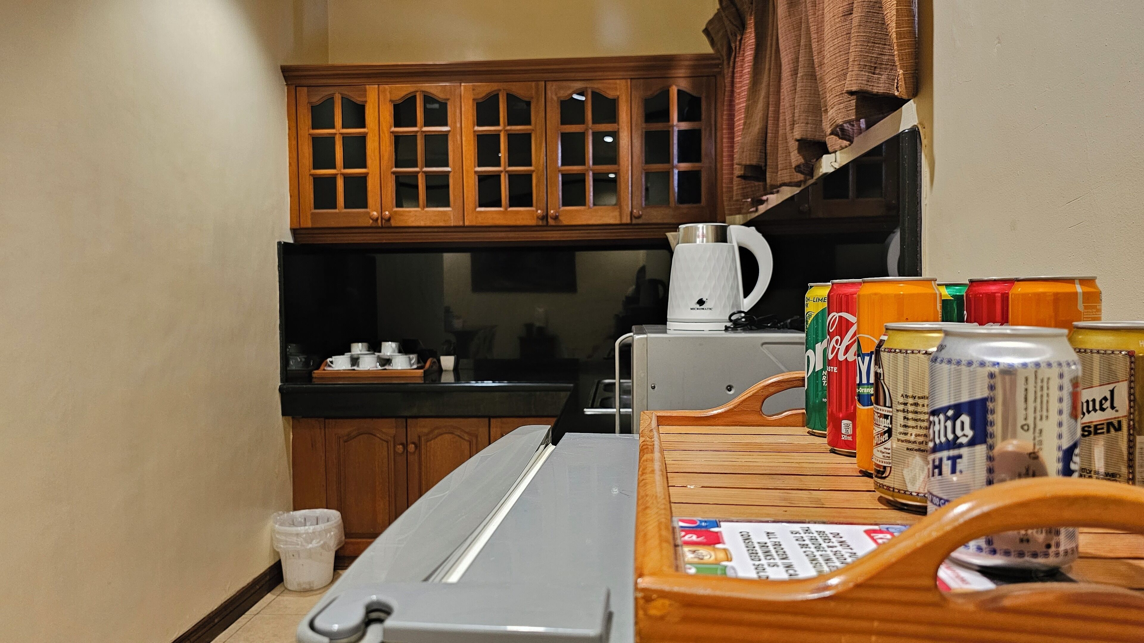 Eine Küche mit Holzausstattung, einer Kaffeemaschine und einem Tisch mit verschiedenen Getränkedosen.