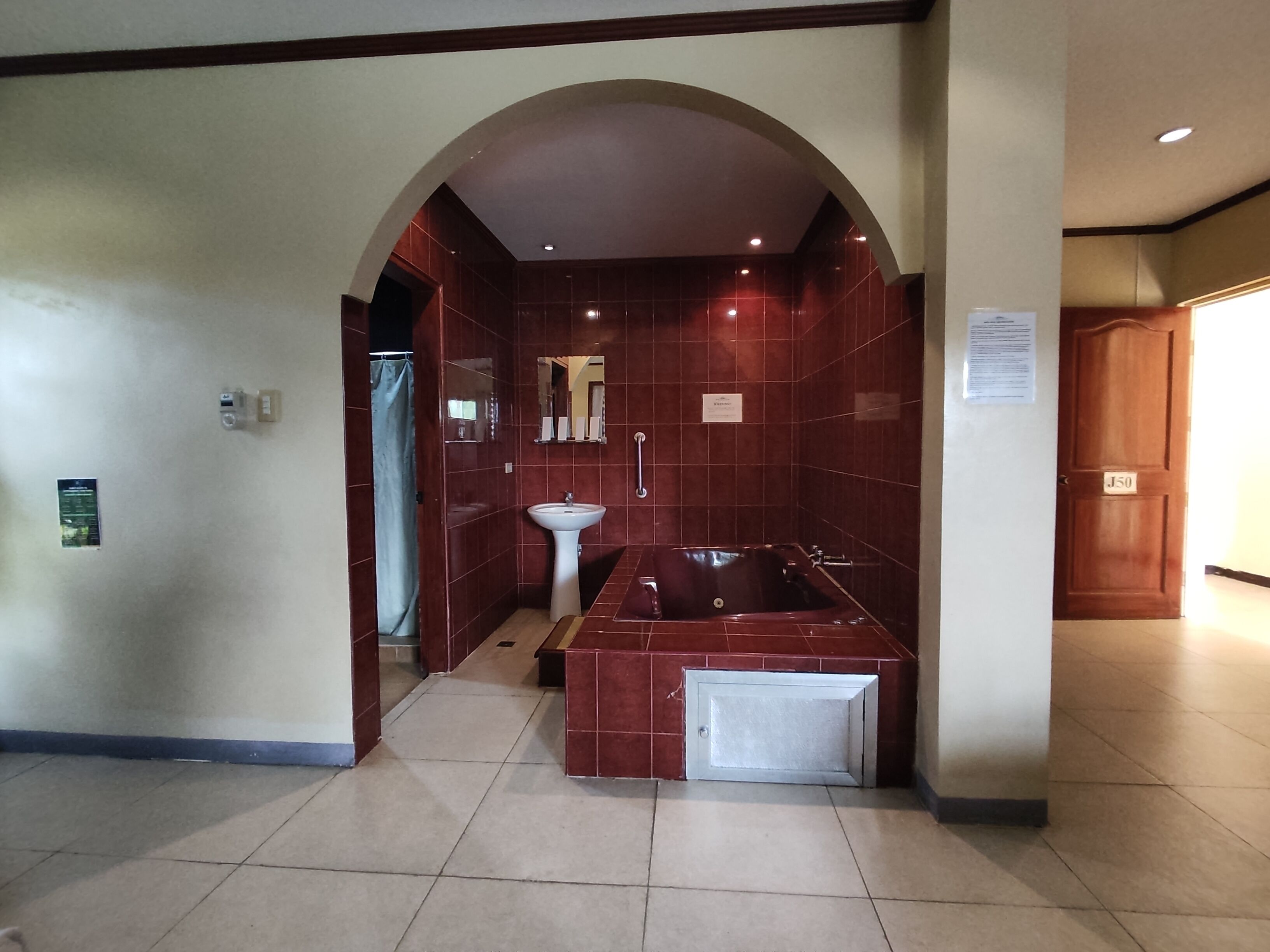 A bathroom with a large bathtub, a sink, and a shower area.