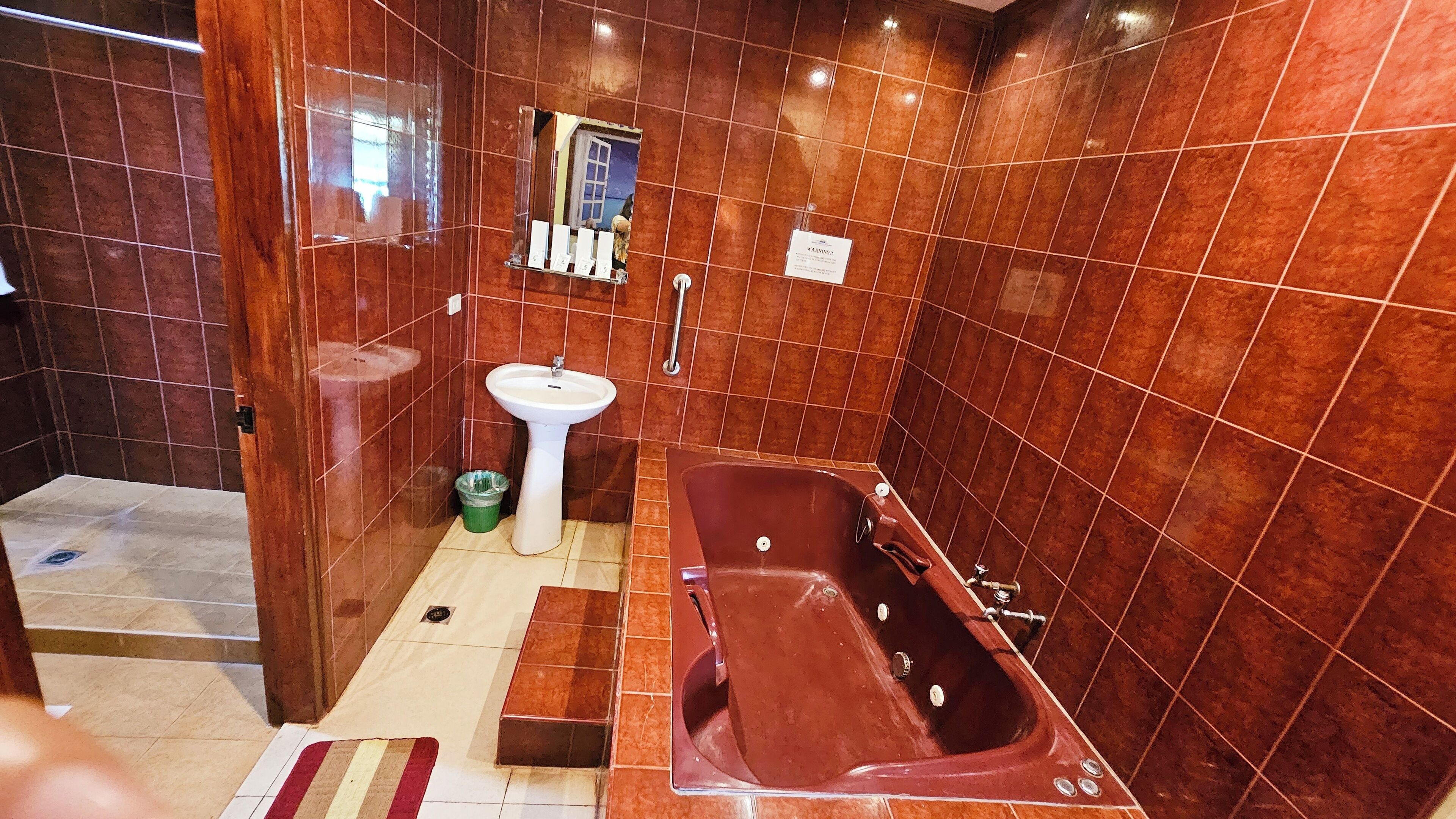 A bathroom with a bathtub, sink, and tiled walls.