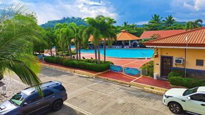 Un complexe hôtelier doté d’une piscine, de palmiers et d’un parking.
