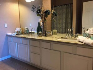A bathroom with a large vanity, two sinks, and a mirror. - Tideview #85 · 3 Suites Near Convention, Universal & Disney (Orlando)