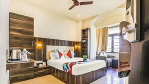 A modern hotel room with a bed, bedside table, and a "Don't Disturb" sign. - Hotel Airport International (New Delhi)