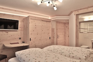 Une chambre à coucher avec un lit, une coiffeuse et un téléviseur.