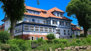 A large, two-story building with a sign reading "INSELSTUBE" at the bottom.