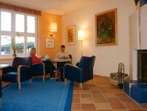 A room with two armchairs, a small table, and a fireplace. - Apartment (2) - Apartments in Kloster (Insel Hiddensee)