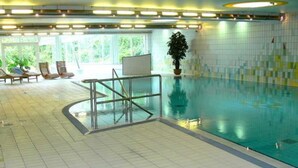 An indoor swimming pool with a tiled floor, a glass barrier, and a potted plant. - Apartment (2+2) - Apartments in Kloster (Insel Hiddensee)