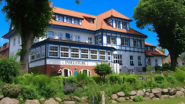 A large, two-story building with a sign reading "INSELSTUBE" at the bottom. - Apartment (2+2) - Apartments in Kloster (Insel Hiddensee)