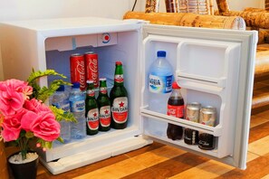 Ein Kühlschrank mit Getränken und einer Topfpflanze.
