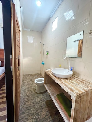 Ein Badezimmer mit Toilette, Waschbecken mit Spiegel und Dusche.