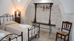 Une chambre à coucher comprenant un lit, une chaise, une table en bois et un porte-manteau mural.