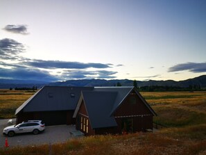 A two-story building with a sloped roof, a garage, and a small attached shed. - Peaceful countryside stay in Central Otago (Waikerikeri)