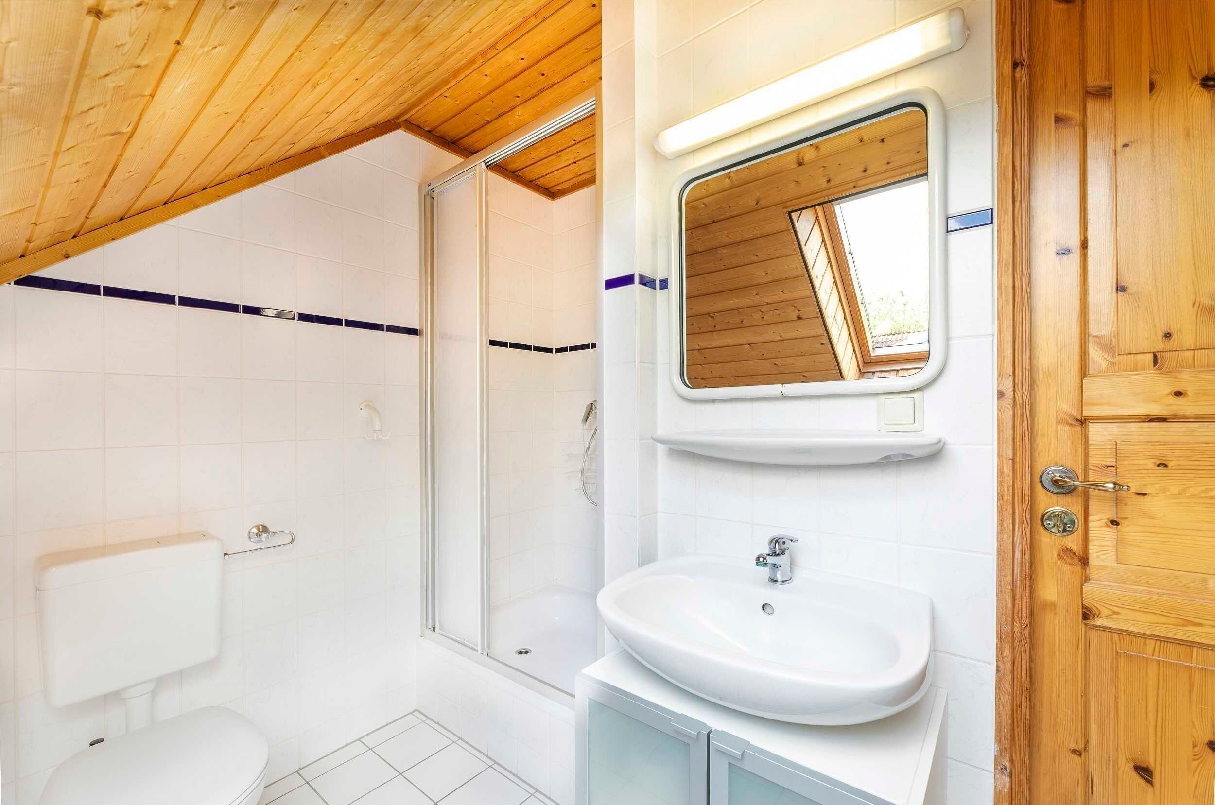 Une salle de bain moderne équipée d’une douche, de toilettes et d’un lavabo.