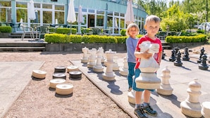 A chessboard set up outdoors in front of a building with a sign reading "Zum Seeadler".
