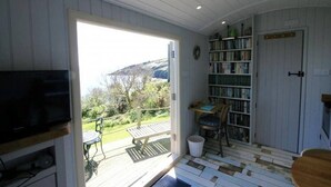 Une pièce comprenant une télévision, une bibliothèque, un bureau et une chaise.
