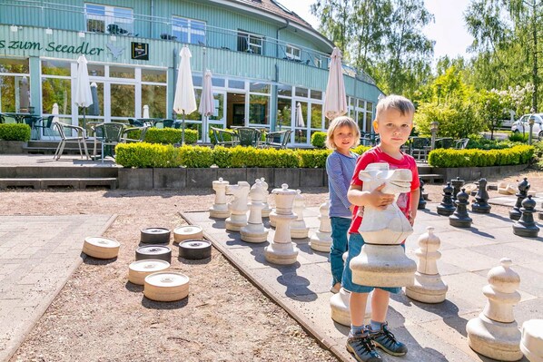 A chessboard set up outdoors with a building in the background.